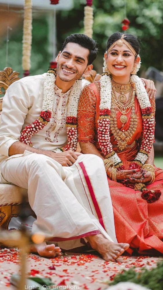 Couple outdoors, bride in red Kanjivaram saree
